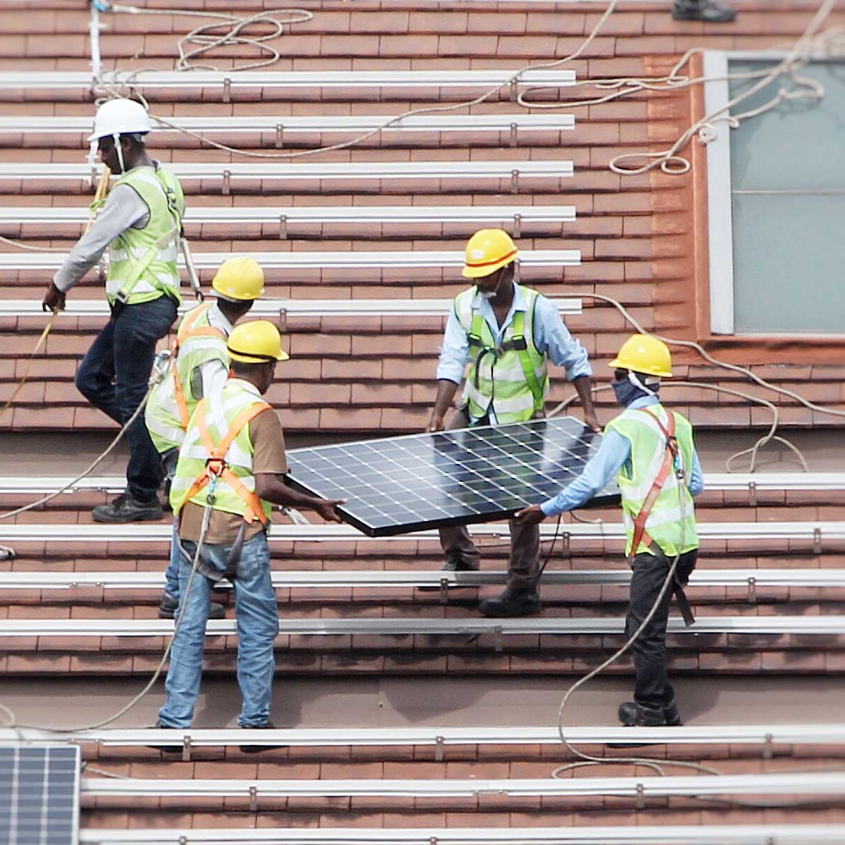 Professional sustainability communications & training | Image of 4 men installing a solar panel
